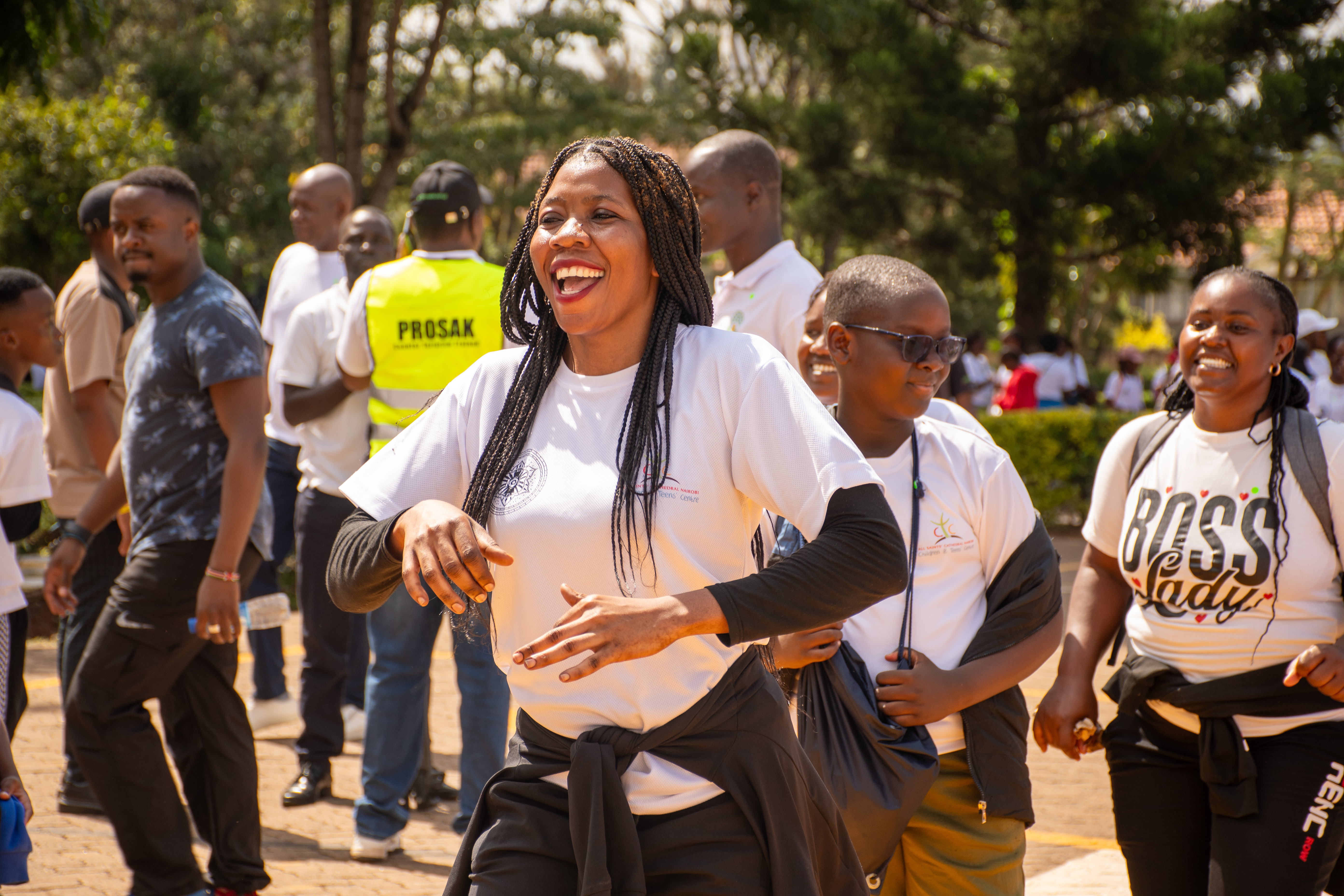 Woman with braids laughing and dancing at an outdoor community event